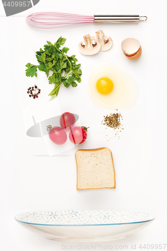 Image of The falling ingredients of fried egg. Healthy breakfast ingredients.