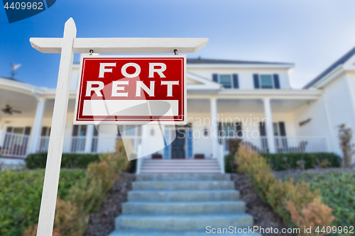 Image of Right Facing For Rent Real Estate Sign In Front of House.