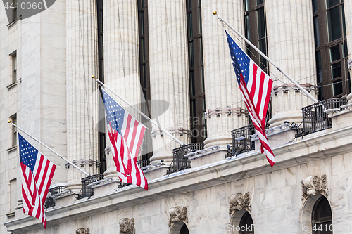 Image of American flags waving on exterior of New york Stock Exchange, Wall street, lower Manhattan, New York City, USA.