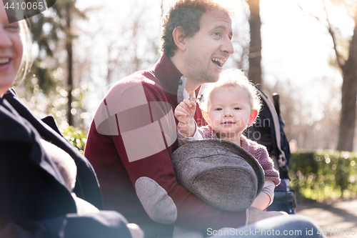 Image of Young family with cheerful child in the park.