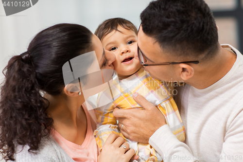 Image of happy mother and father kissing baby daughter