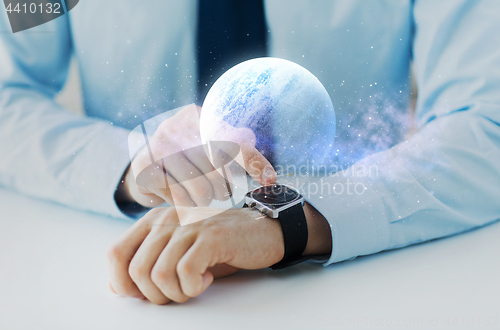 Image of hands with planet hologram over smart watch