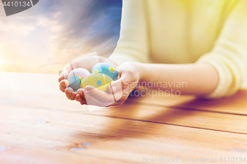 Image of close up of woman hands with colored easter eggs