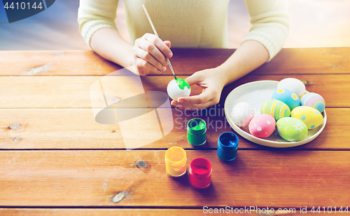 Image of close up of woman hands coloring easter eggs