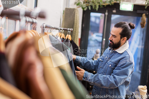 Image of man choosing clothes at vintage clothing store