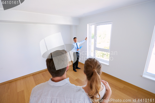 Image of realtor with clipboard and couple at new home