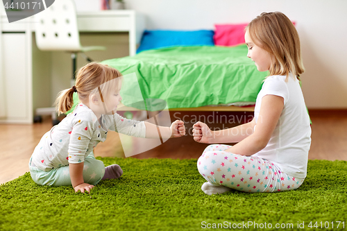 Image of girls playing rock-paper-scissors game at home