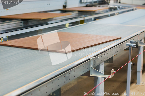 Image of wooden boards on conveyer at furniture factory