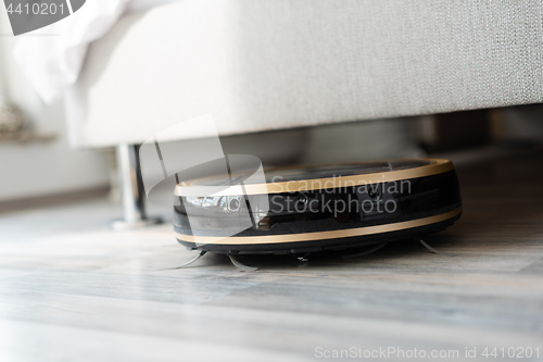 Image of Robot vacuum cleaner runs under bed