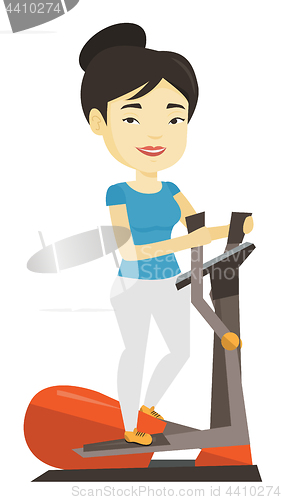 Image of Woman exercising on elliptical trainer.