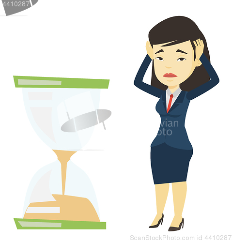 Image of Desperate business woman looking at hourglass.