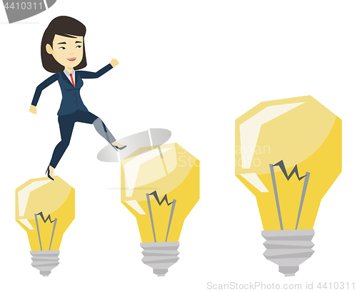 Image of Business woman jumping on light bulbs.