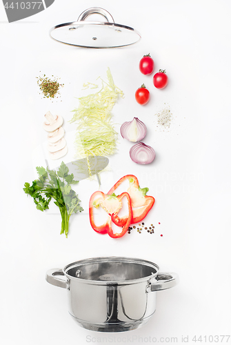 Image of Assorted fresh vegetables falling into a bowl, on white background