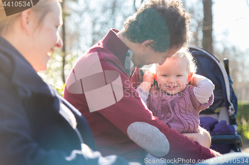 Image of Young family with cheerful child in the park.