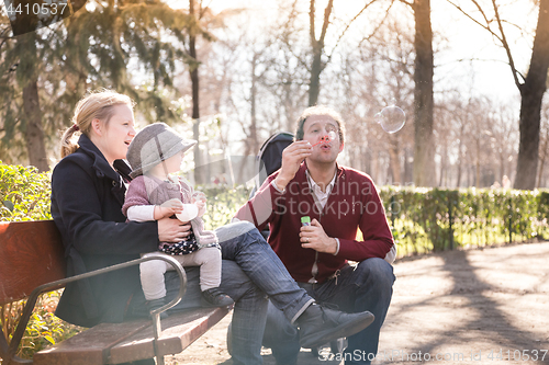 Image of Young family with cheerful child in the park.