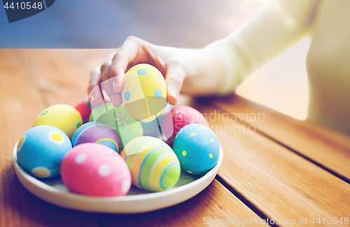 Image of close up of woman hands with colored easter eggs