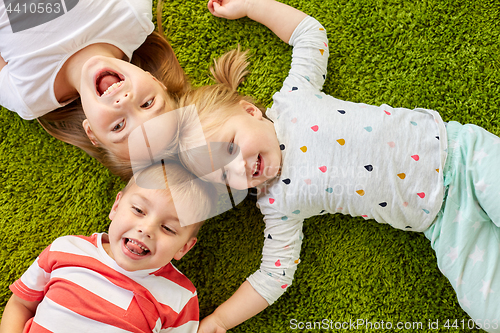 Image of happy little kids lying on floor or carpet