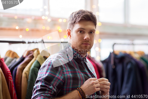 Image of man choosing clothes at vintage clothing store