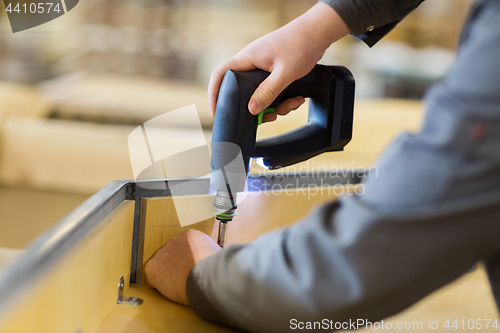 Image of assembler with screwdriver making furniture