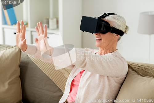 Image of old woman in virtual reality headset or 3d glasses