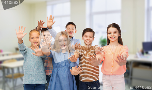 Image of happy students waving hands at school