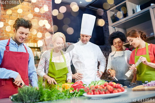 Image of happy friends and chef cook cooking in kitchen