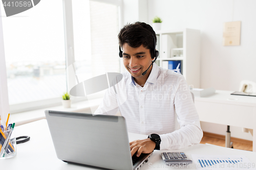 Image of businessman with headset and laptop at office