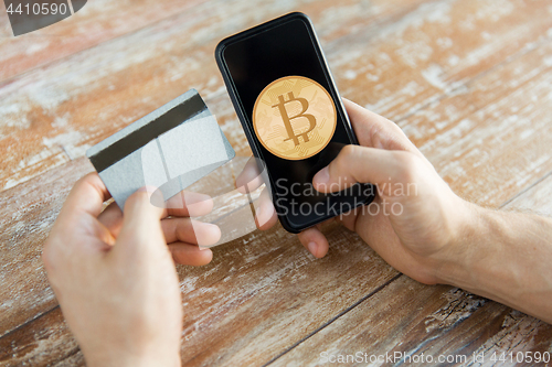 Image of close up of bitcoin on smartphone and credit card