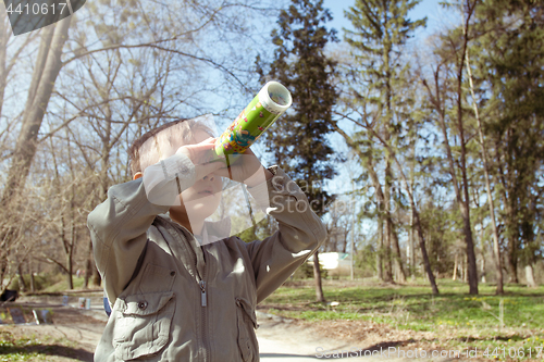 Image of Boy looking at the kaleidoscope outdoors