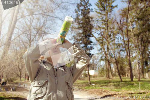 Image of Boy looking at the kaleidoscope outdoors