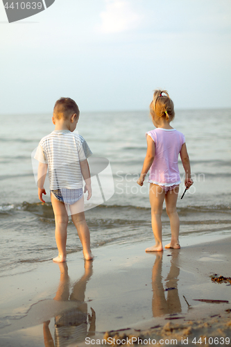 Image of Happy family brother and sister playing on the beach