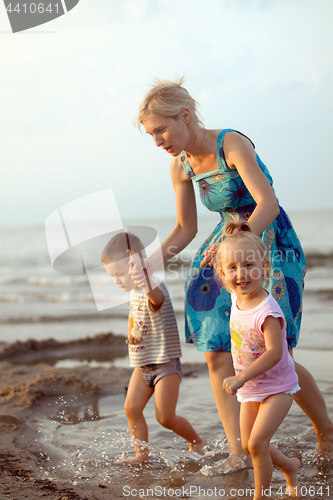 Image of Happy family playing on the beach