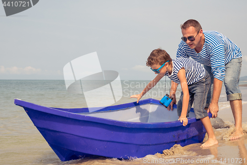 Image of Father and son  playing on the beach at the day time.