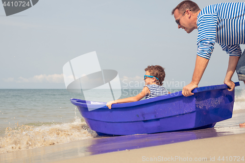 Image of Father and son  playing on the beach at the day time.