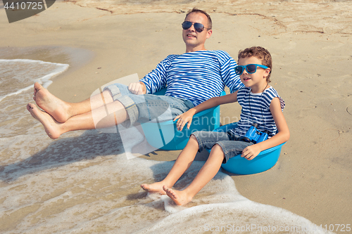 Image of Father and son  playing on the beach at the day time.