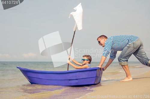 Image of Father and son  playing on the beach at the day time.