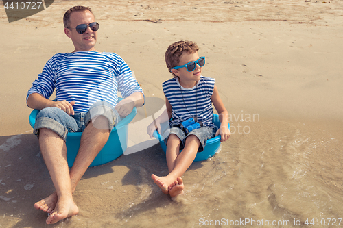 Image of Father and son  playing on the beach at the day time.