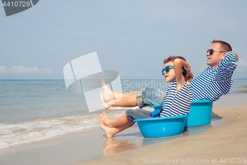 Image of Father and son  playing on the beach at the day time.