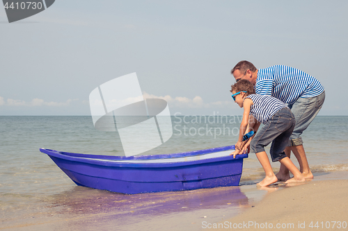 Image of Father and son  playing on the beach at the day time.