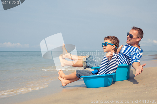 Image of Father and son  playing on the beach at the day time.