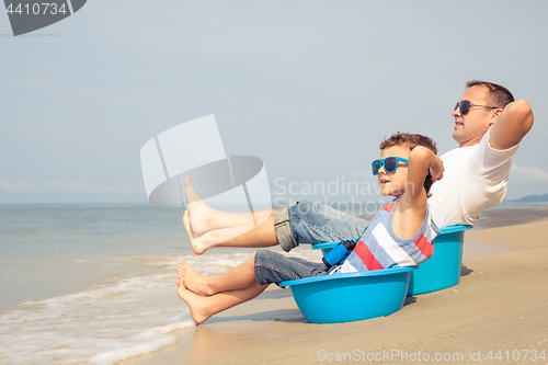 Image of Father and son  playing on the beach at the day time.