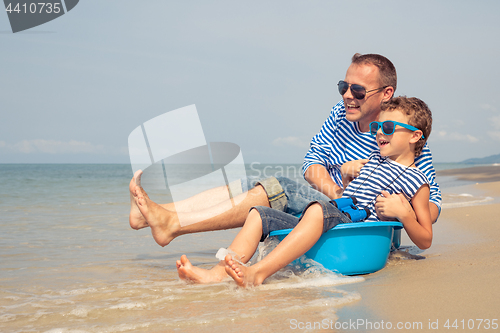 Image of Father and son  playing on the beach at the day time.