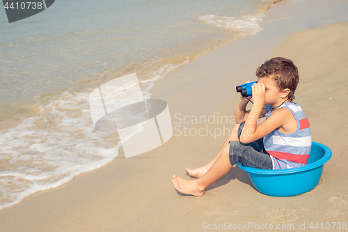 Image of One happy little boy playing on the beach at the day time.