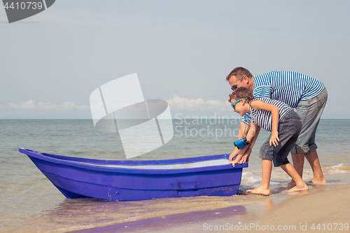 Image of Father and son  playing on the beach at the day time.