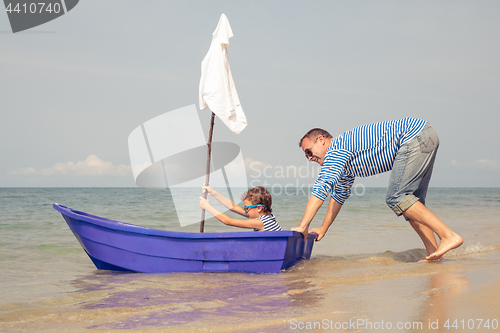 Image of Father and son  playing on the beach at the day time.