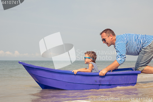 Image of Father and son  playing on the beach at the day time.