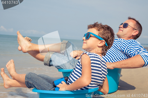 Image of Father and son  playing on the beach at the day time.