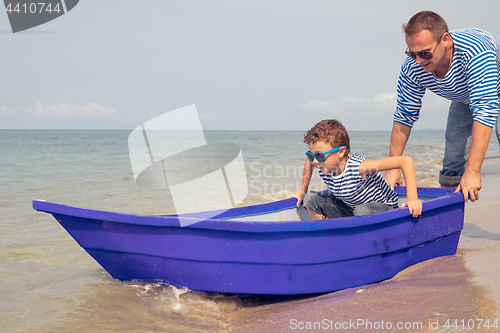 Image of Father and son  playing on the beach at the day time.