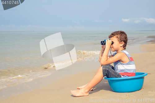 Image of One happy little boy playing on the beach at the day time.