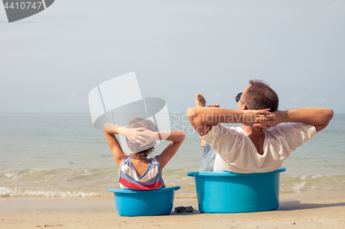 Image of Father and son  playing on the beach at the day time.